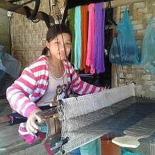 Young girl weaving during summer holiday
