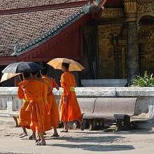 Monks passing by the Vat Mai temple in Luang Prabang